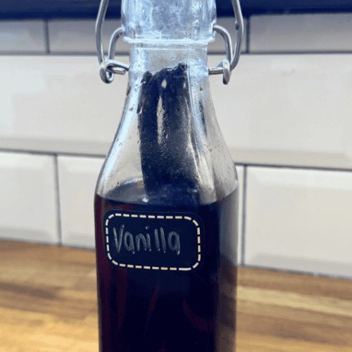 Glass bottle full of brown liquid on kitchen counter with label vanilla extract