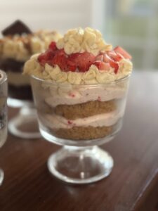 Delicious gluten-free raspberry cheesecake bites topped with fresh strawberries and cake layers.