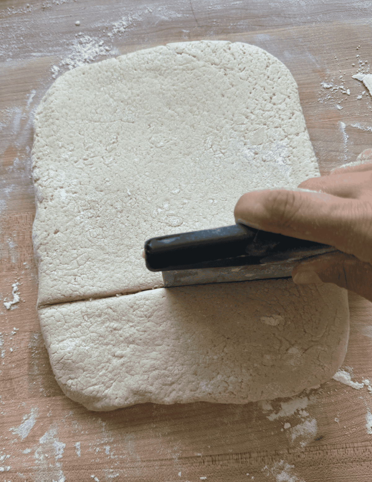 Gluten free beignet dough being sectioned into smaller donut pieces.