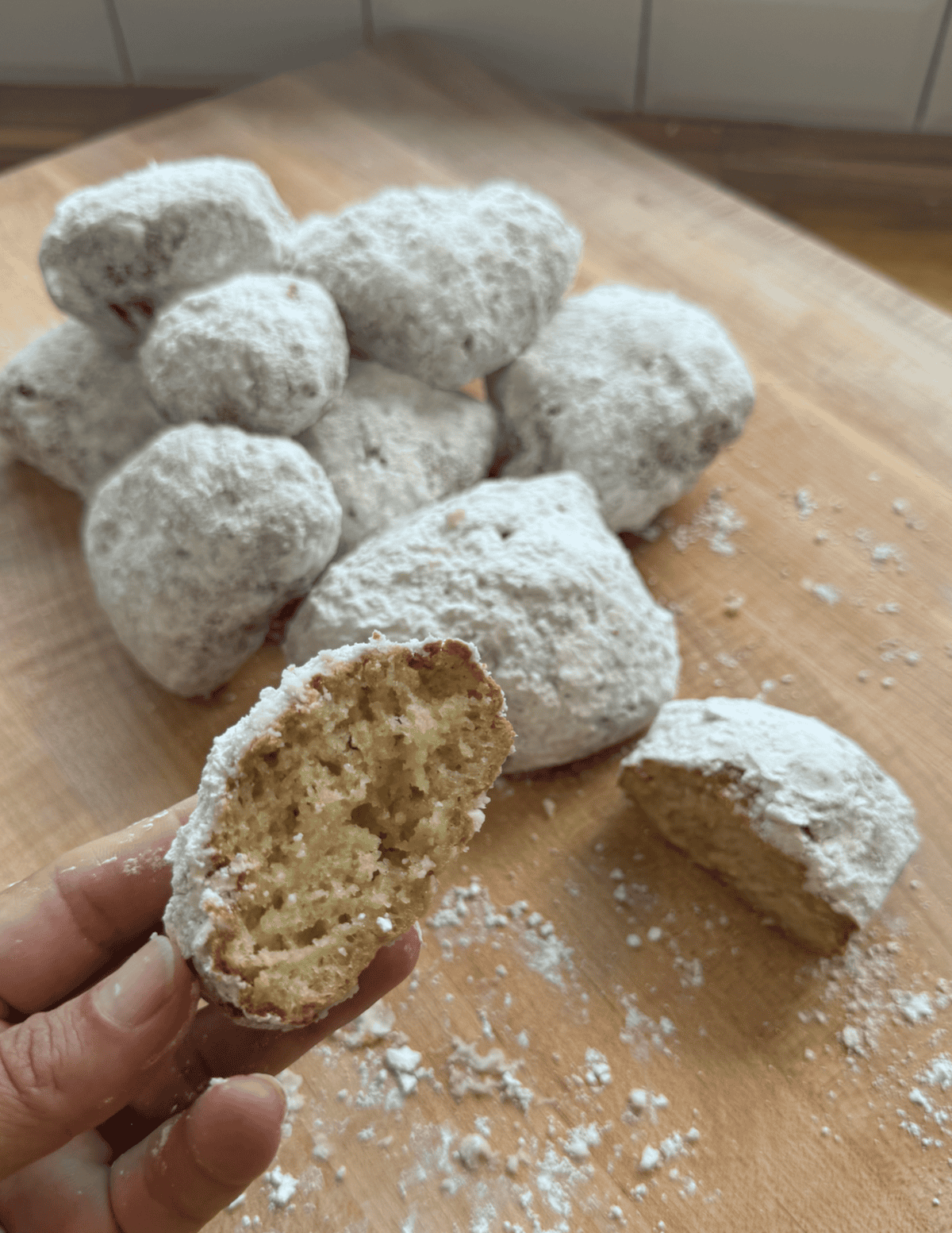 gluten free beignets with a bite taken out of them to show teh pillowy soft inside.