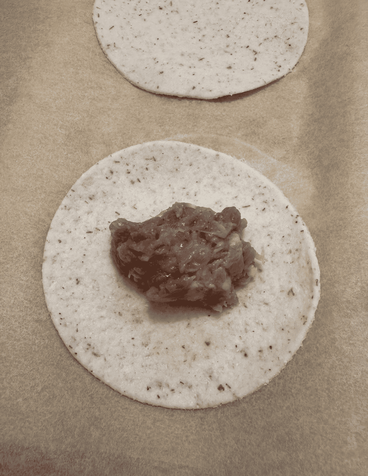 gluten free dumpling circle with meat filling inside.