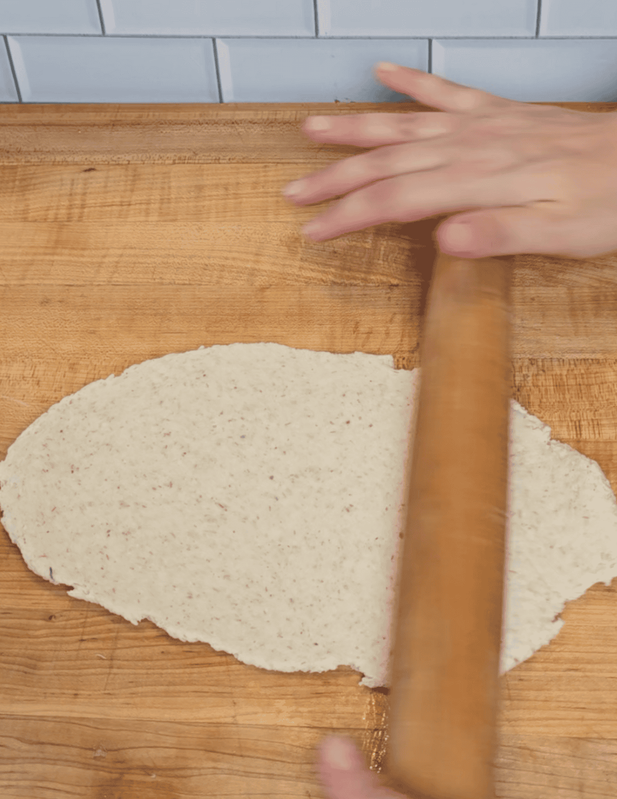 gluten free dumpling dough being rolled out with a wooden roller