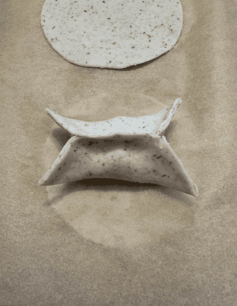 folding a gluten free dumpling step 3 mimicking the other side with the triangle fold and connection