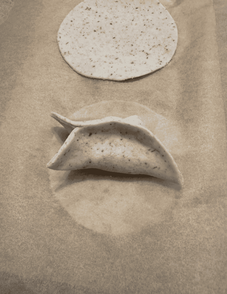 folding a gluten free dumpling step 4 wrapping one side down to form a half moon