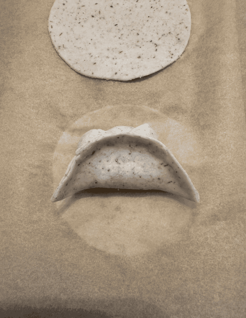 folding a gluten free dumpling step 6 folding the other side down to complete a half moon shape