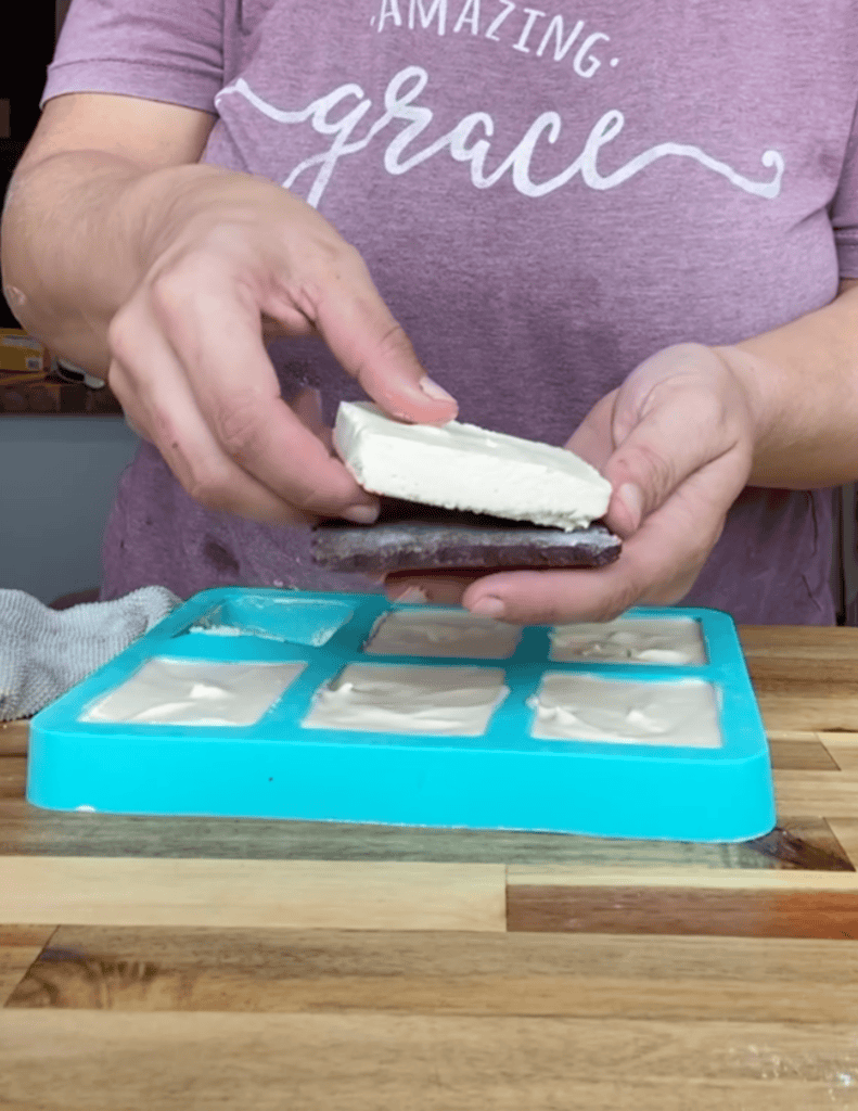 gluten free ice cream sandwich filing being placed on top of a chocolate cookie shell.