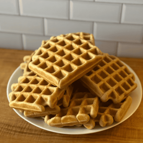 Gluten Free Waffles stacked onto a white plate.