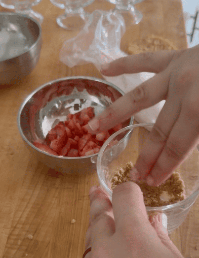 Hands adding fresh ingredients to bowls for gluten-free dessert.