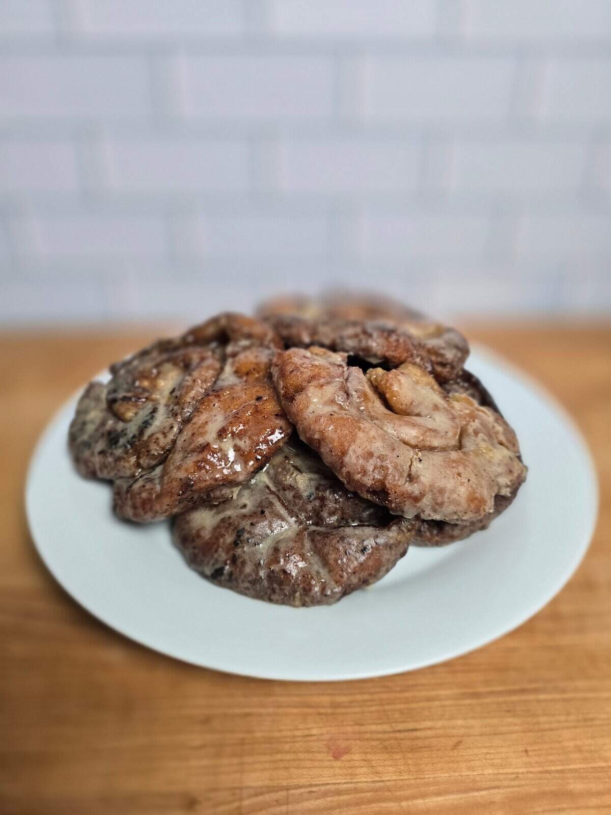 Soft, gluten free honey buns on a white plate.