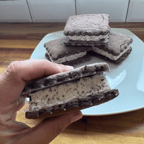 gluten free ice cream sandwiches, one in hand and 2 on plate.