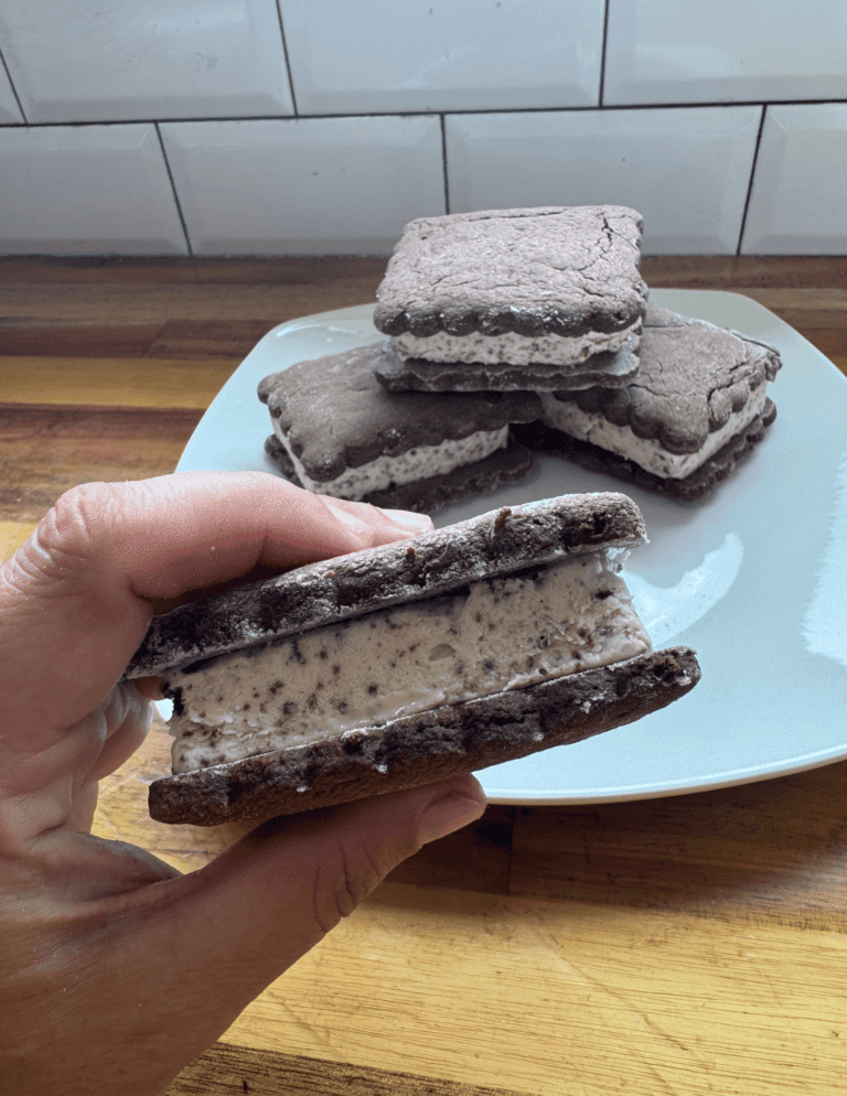 gluten free ice cream sandwiches, one in hand and 2 on plate.