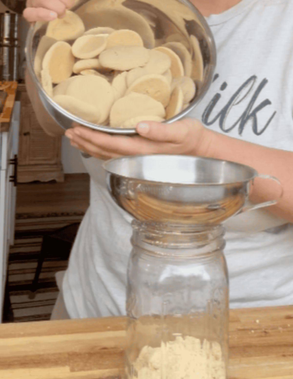 Nilla wafers being crushed into a jar.