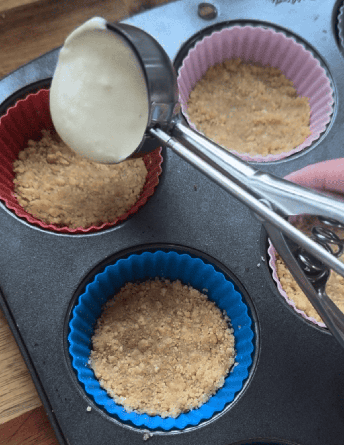 gluten free raspberry cheesecake bites being prepared with the second layer of cheesecake