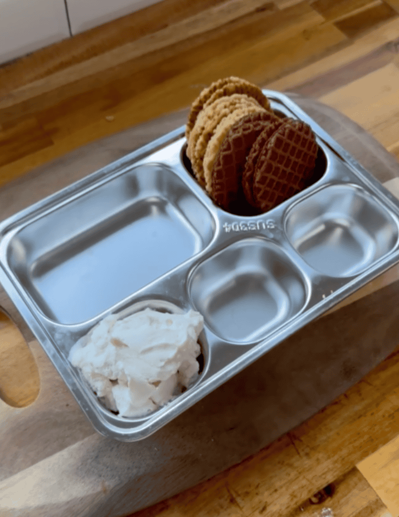 Ice cream nachos with homemade pizzelle cookies in a metal tray.