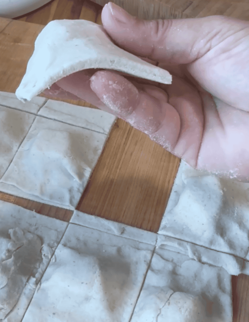 Fresh handmade dumpling being prepared with dough and filling.