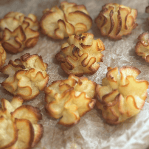 Pastry bites with a drizzle of chocolate, freshly baked and golden brown, perfect for snacks or dess.