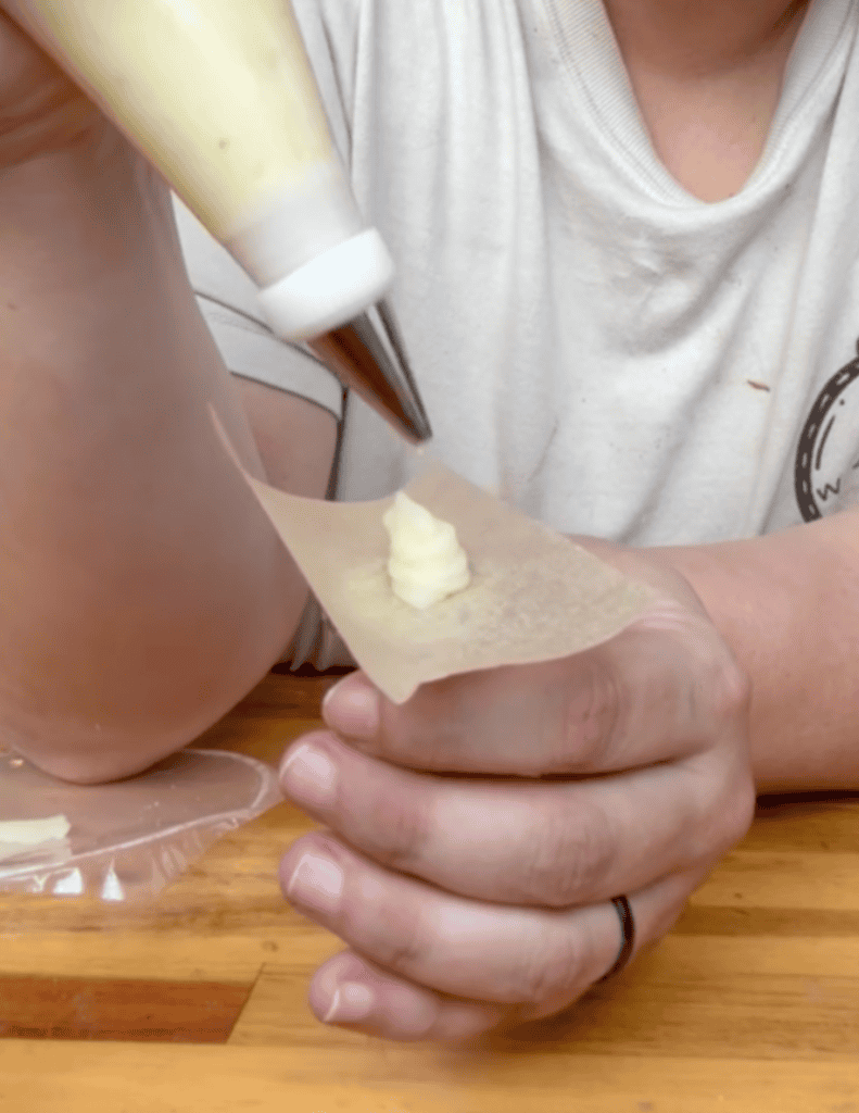 Child making homemade butter with a piping bag at Farm Fresh Family.