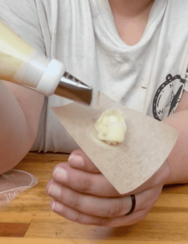 Homemade ice cream being piped onto a cone by a child, showcasing fresh, farm-sourced ingredients.