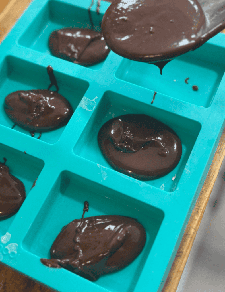 Delicious homemade chocolate lollipops cooling in a silicone mold. Perfect for treats or gifts, made.