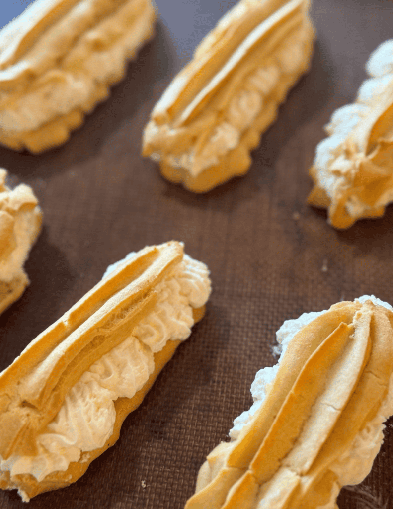 Freshly baked cream-filled eclairs with golden pastry and creamy filling.