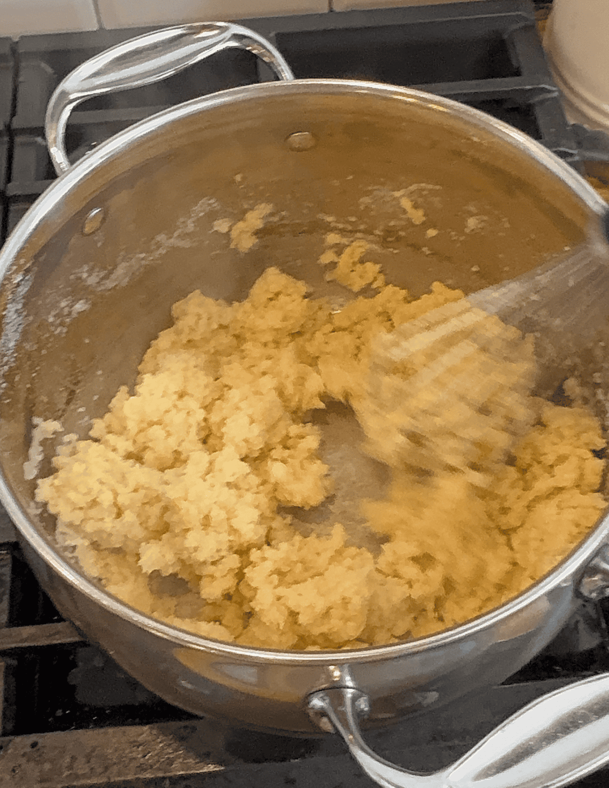 Whisking the dry ingredients into the French cruller recipe and forming with the butter.