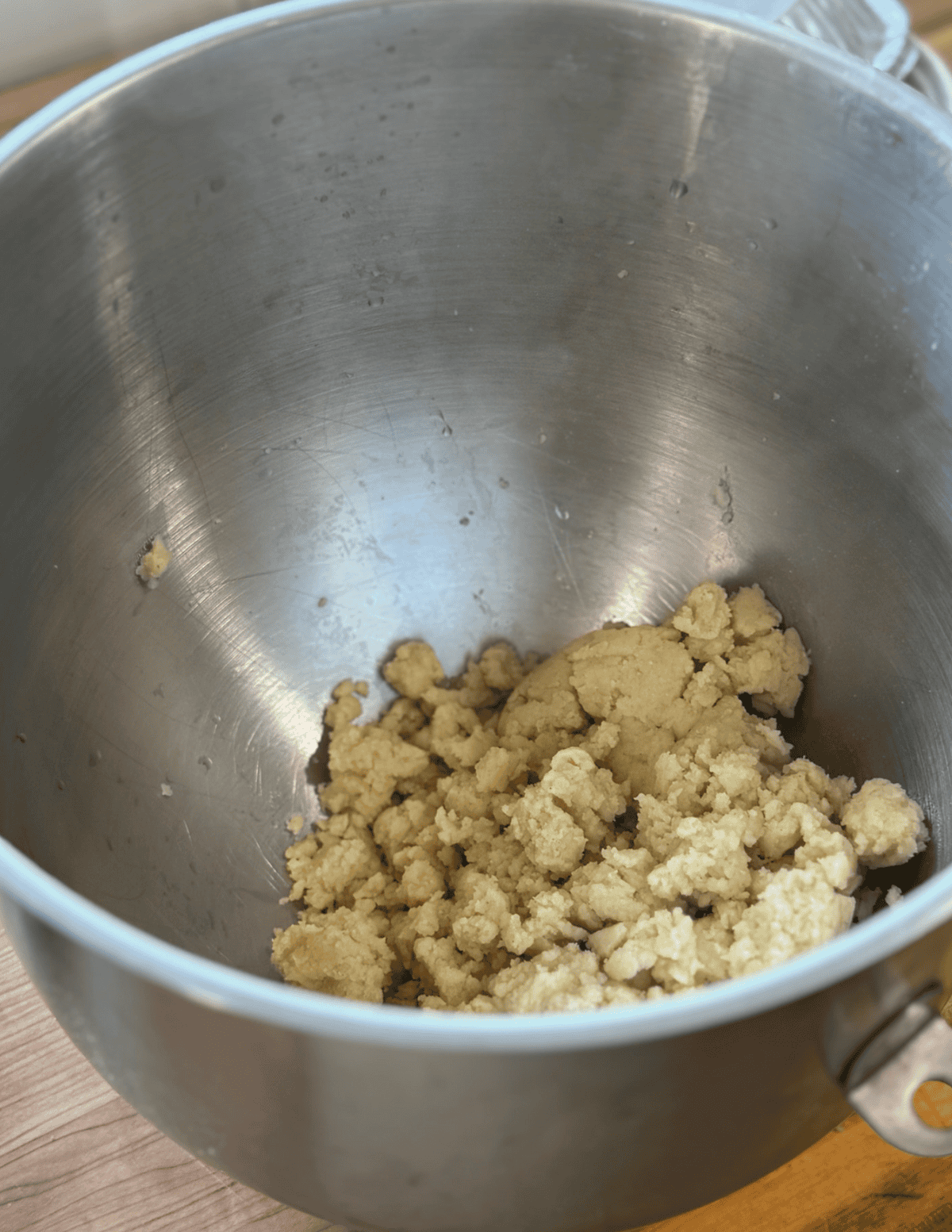 Dough mixture in a stainless steel stand mixer bowl, ready for baking or cooking.