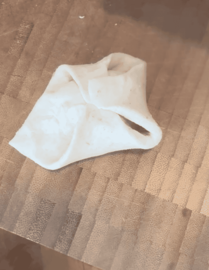 Soft homemade tortilla resting on a wooden cutting board.