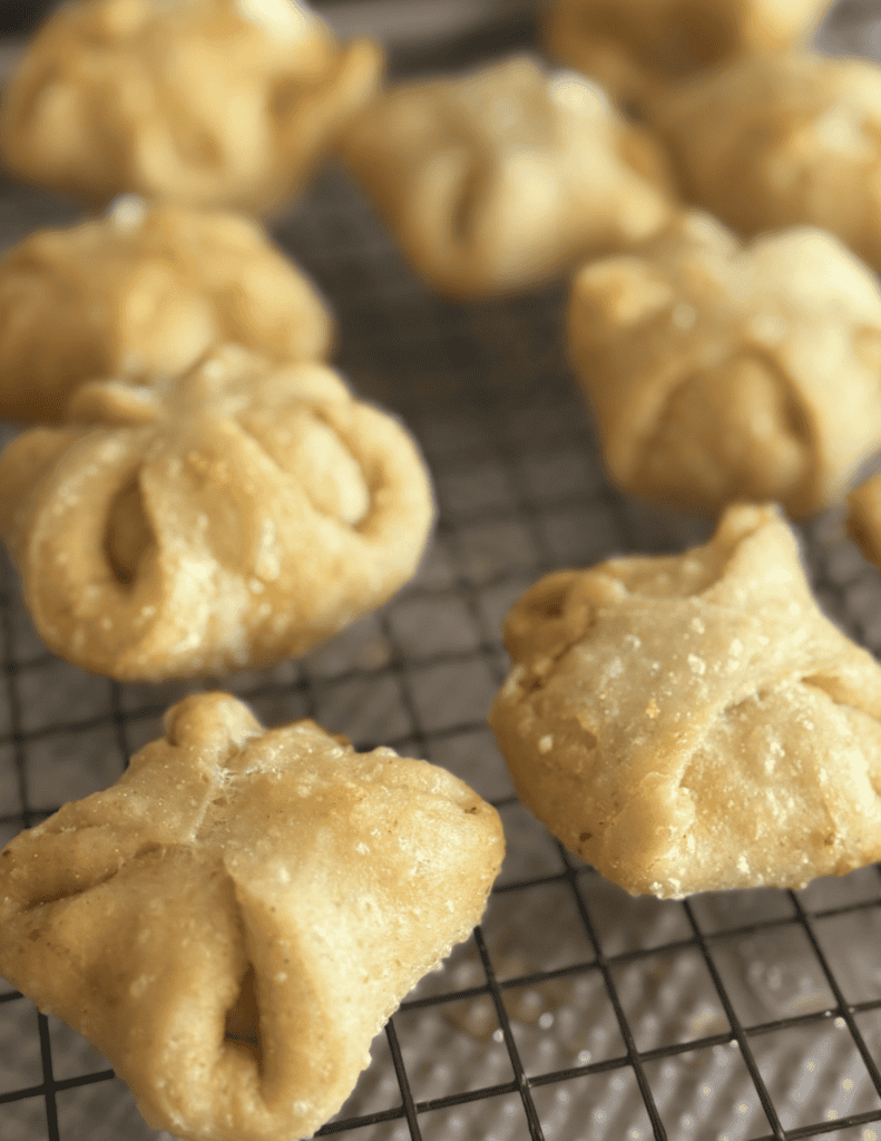 Freshly fried pastries cooling on a wire rack, golden and crispy.
