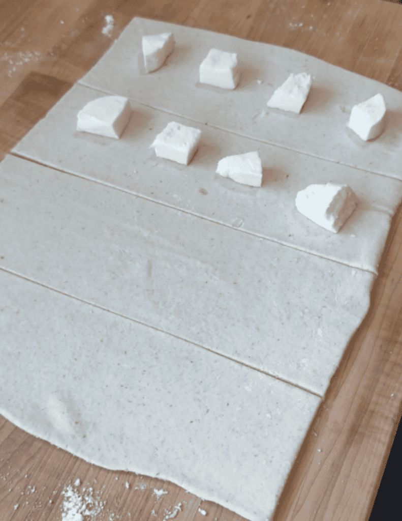 Fresh cheese samples on parchment paper, ready for tasting.