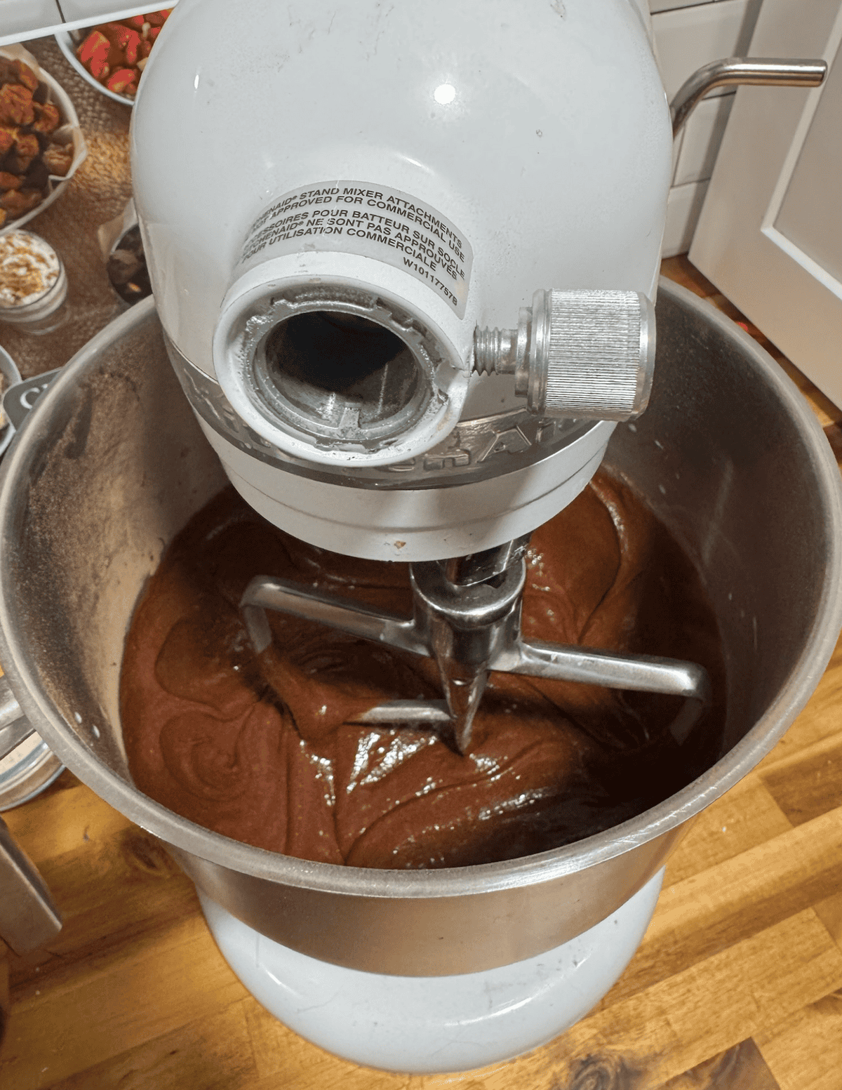Homemade chocolate frosting being mixed in a stand mixer for fresh baking.
