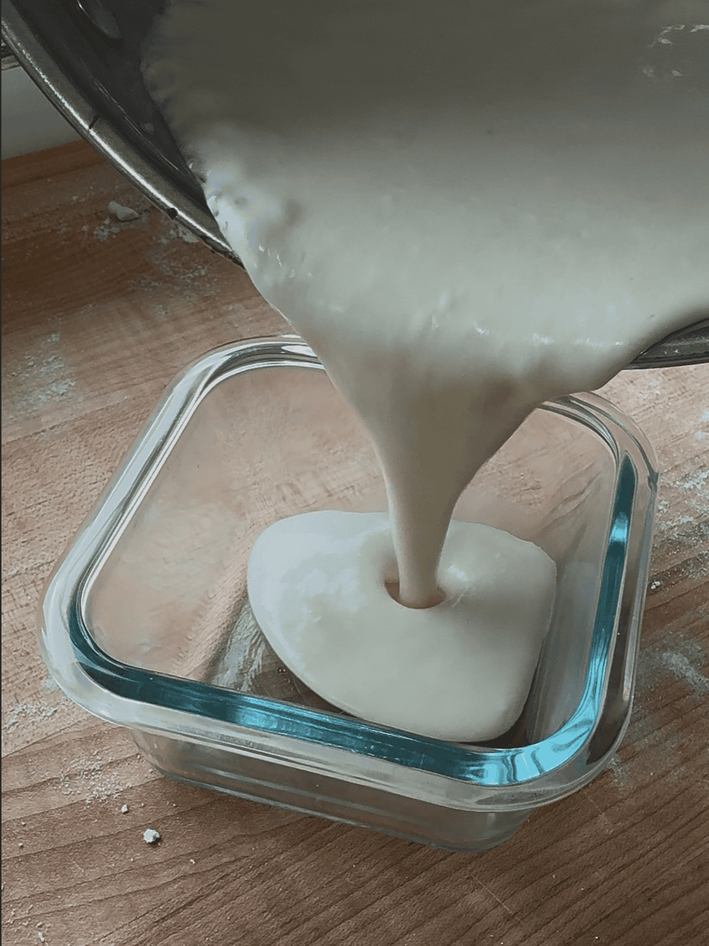 cheese sauce pouring into a glass container