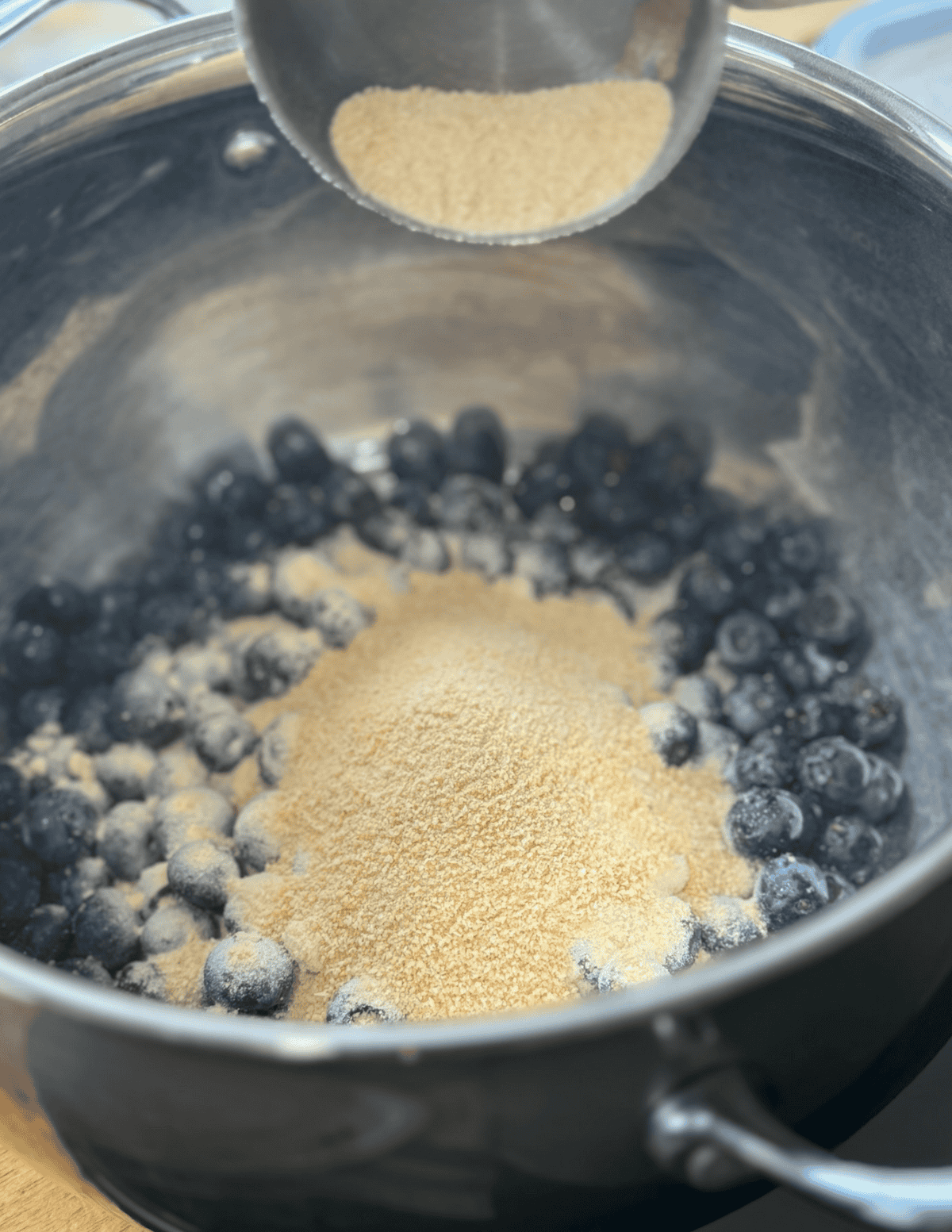 Fresh blueberries and sugar in a cooking pot for homemade blueberry jam.