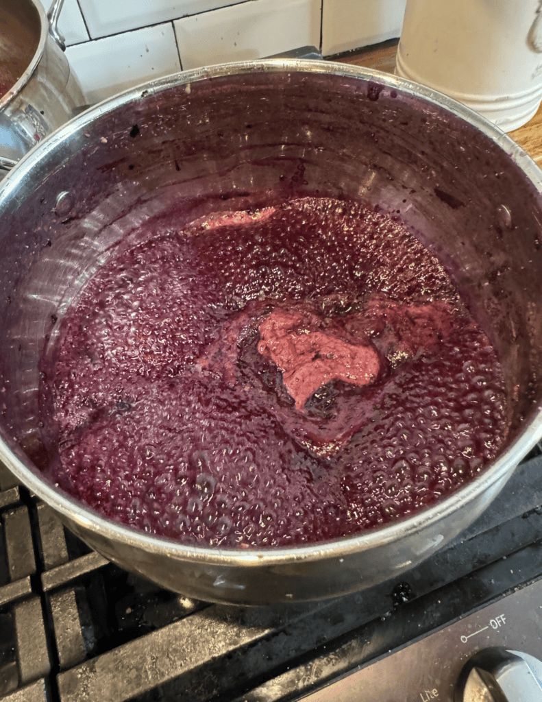 Freshly cooked homemade berry jam in a stainless steel pot.