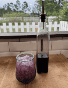 Fresh fruit syrup in a glass and bottle for beverages or desserts.