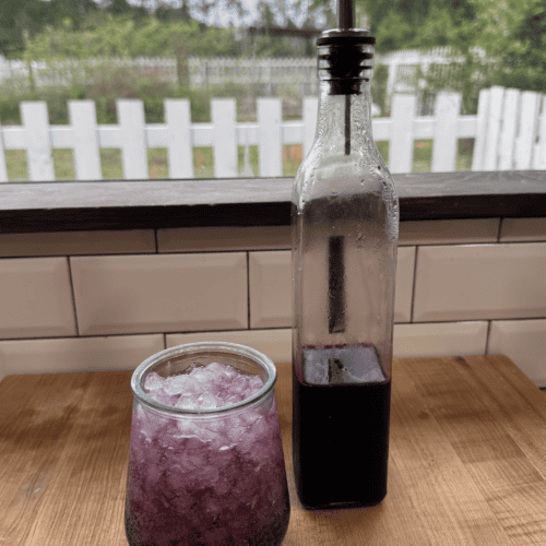 Fresh fruit syrup in a glass and bottle for beverages or desserts.
