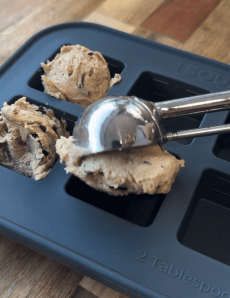 storage container being filled with gluten free cookie dough