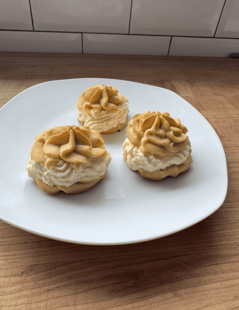 Cookies with creamy frosting and caramel topping on a white plate.