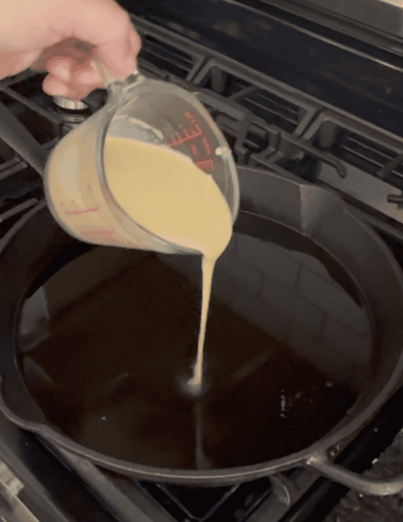 pouring batter for funnel cake in hot oil