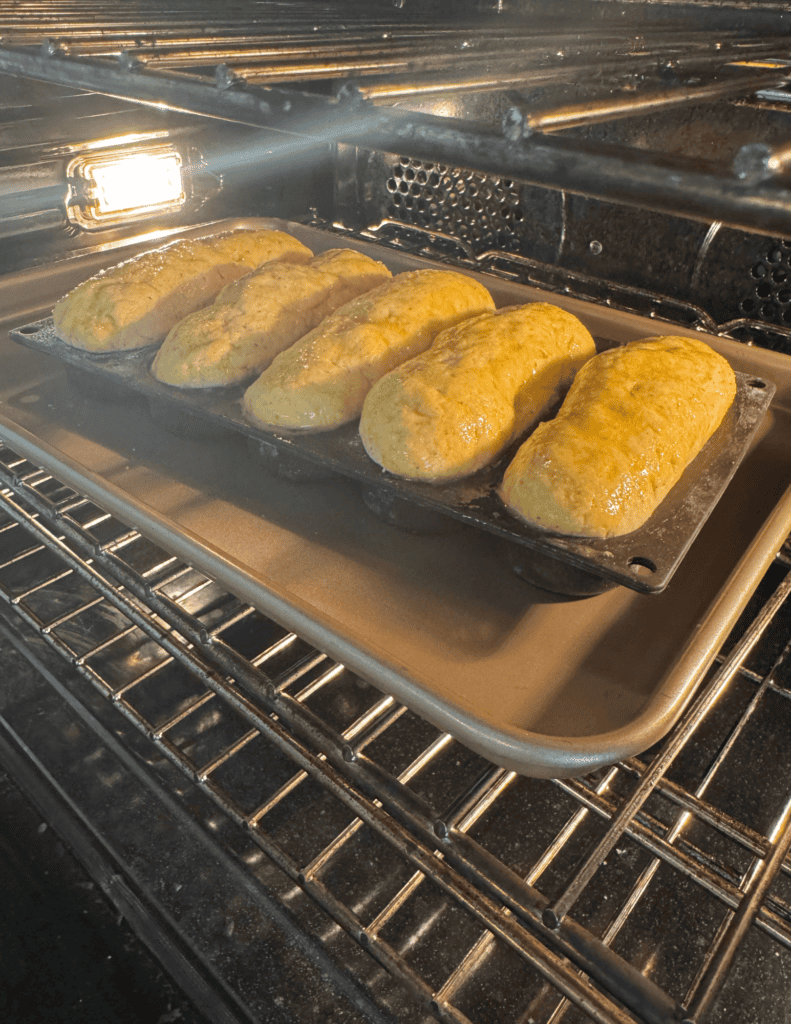 egg wash on gluten free hot dog buns going into the oven.
