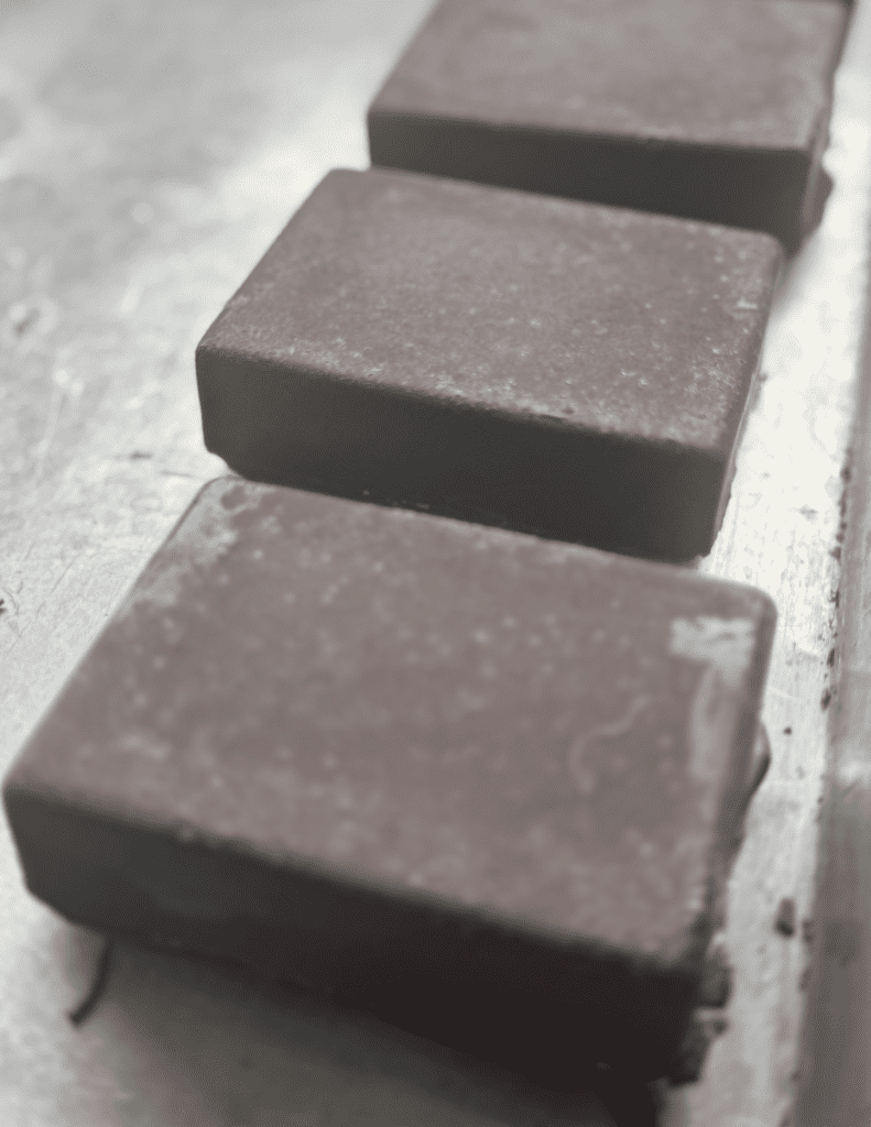 Freshly made dark chocolate bars on a rustic wooden surface.