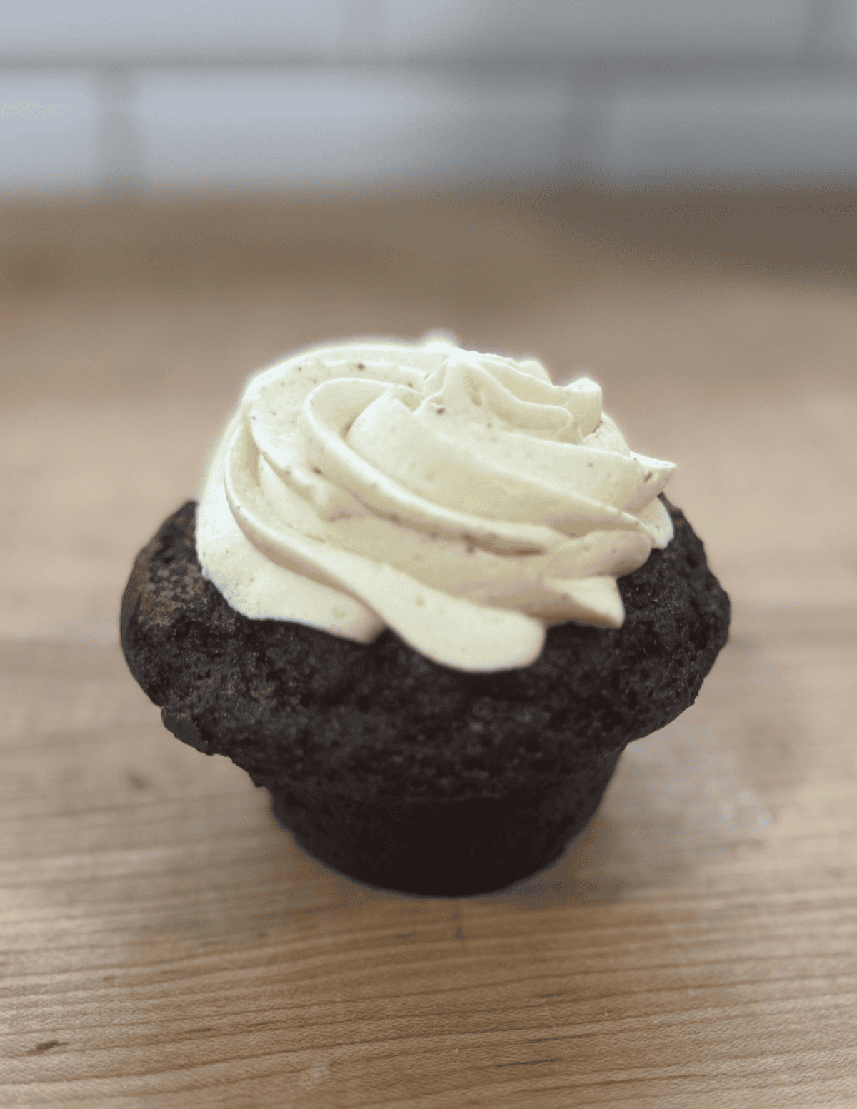 Chocolate cupcake with vanilla frosting, perfect for farm-fresh baked goods and desserts.