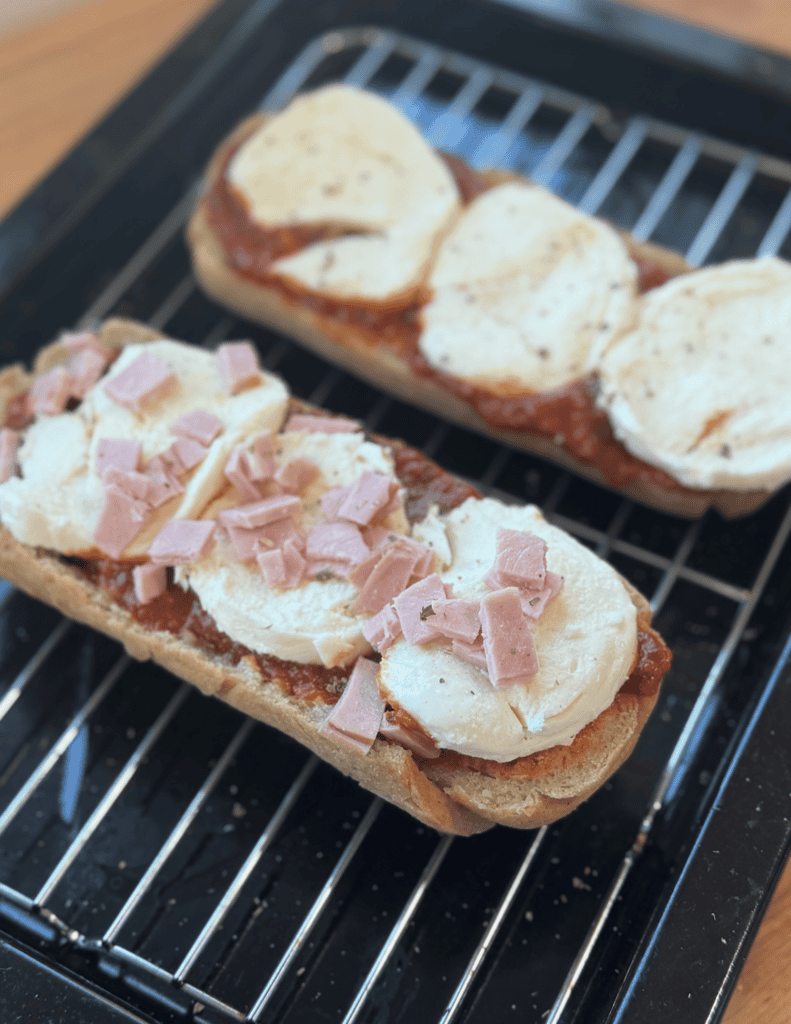 Fresh homemade sandwiches with cheese, ham, and tomato on bread.