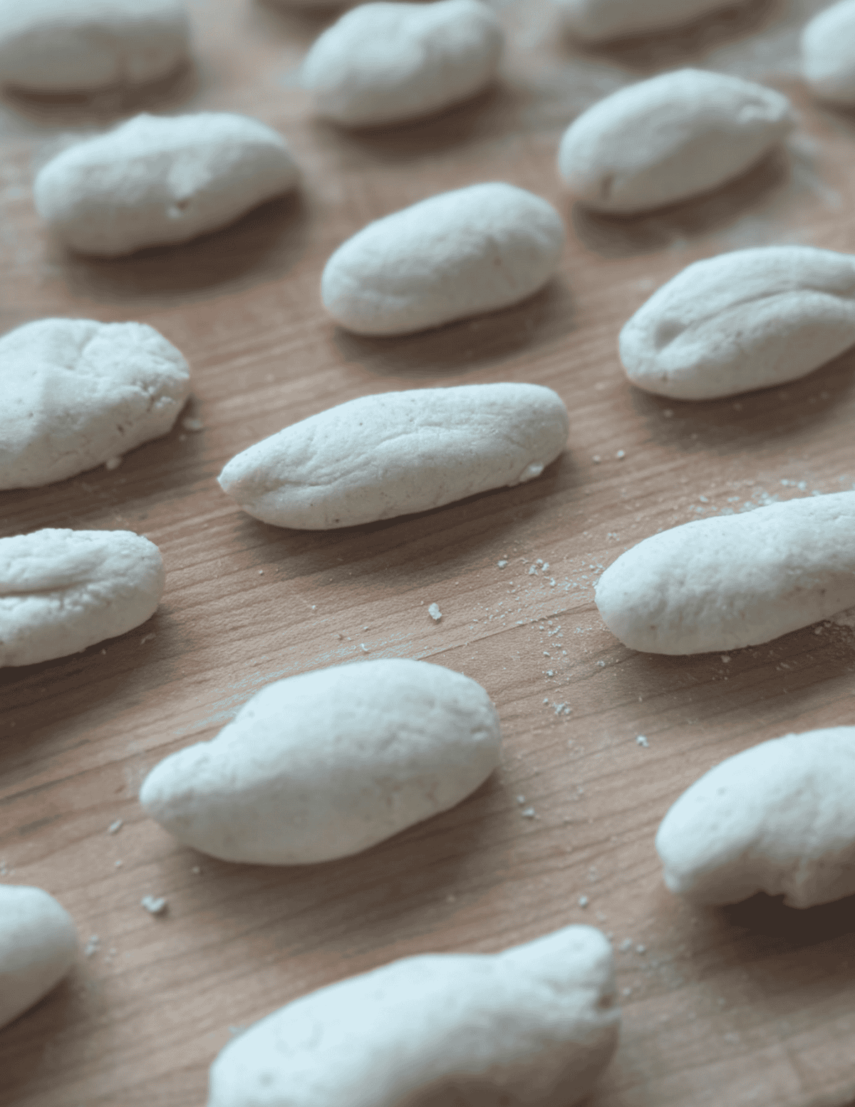 Fresh homemade pasta dough on a wooden surface, ready for cooking.