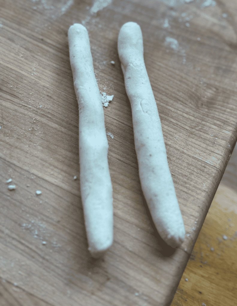 Breadsticks on a wooden surface, showcasing fresh, homemade baked goods.