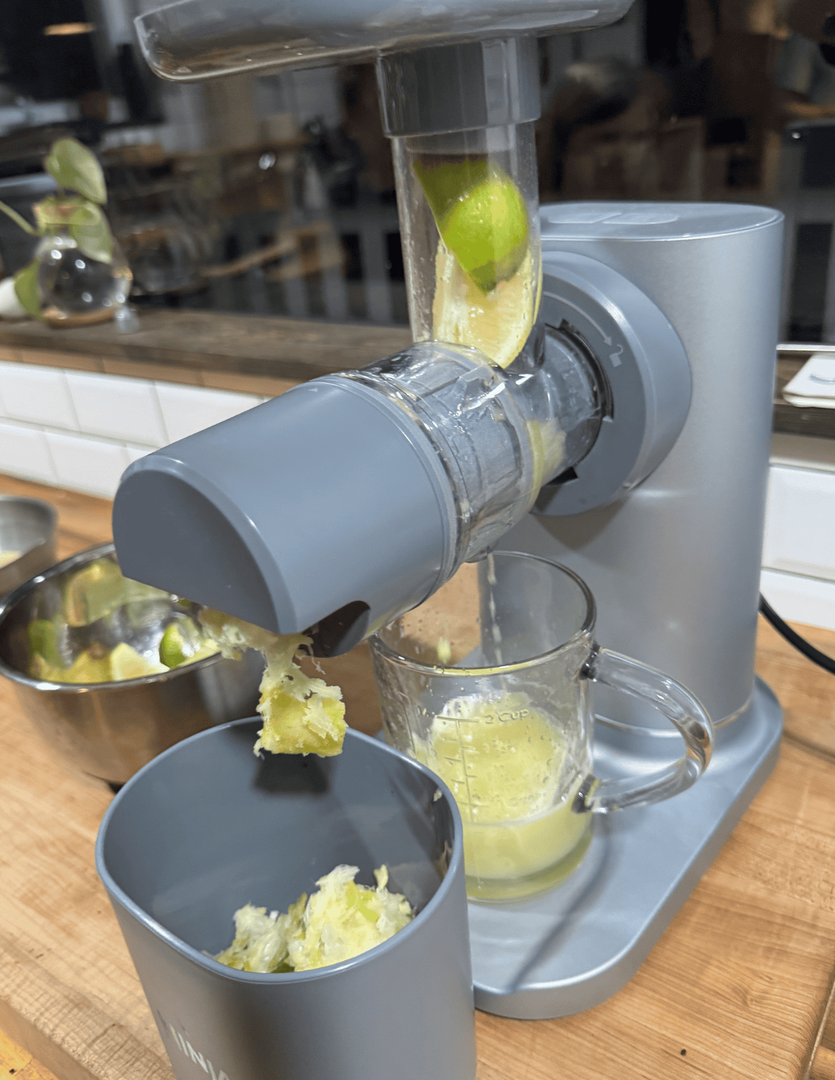 Juicing fresh lemons and limes with a modern electric juicer.
