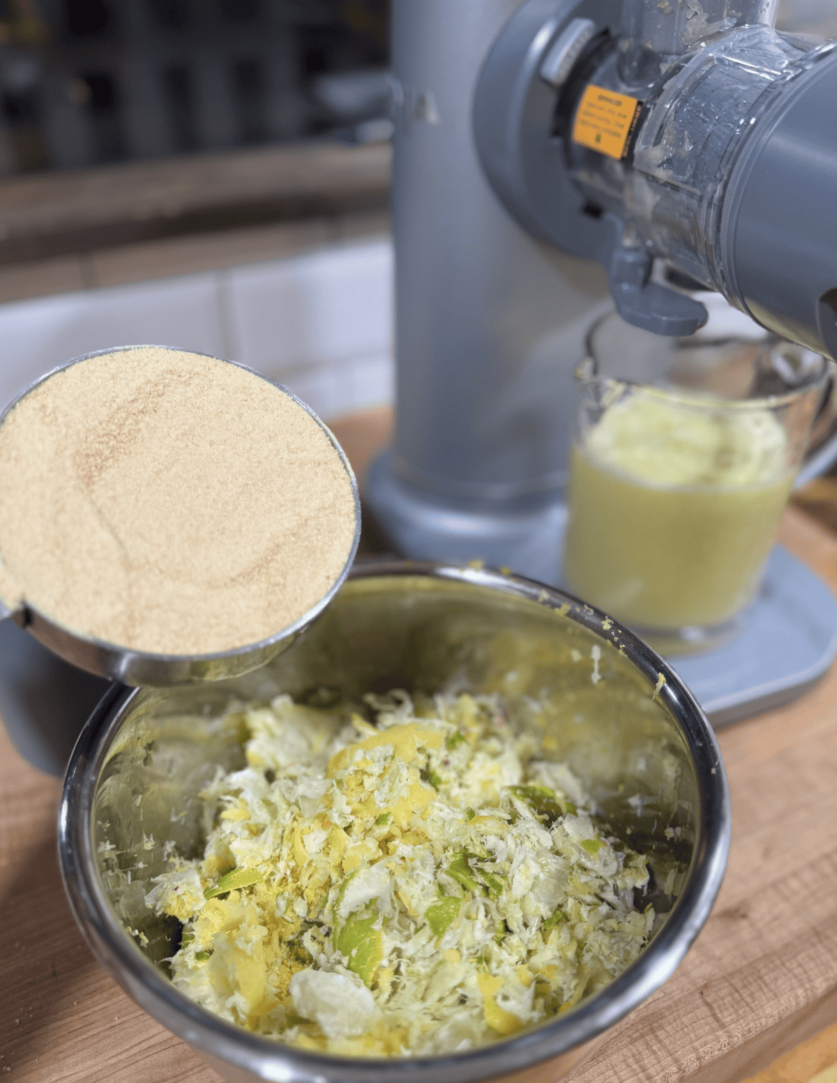 Grated Parmesan cheese being sprinkled over a fresh vegetable salad in a kitchen setting.