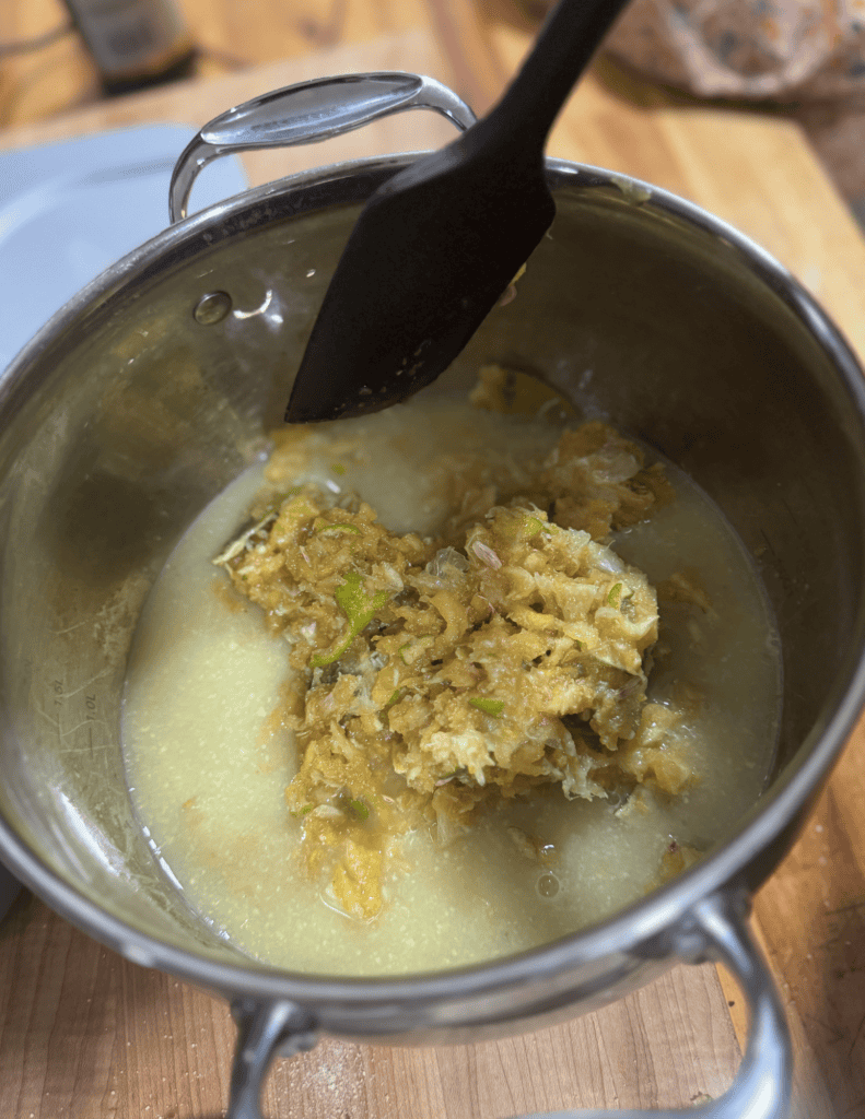 Homemade chicken soup with fresh ingredients, served in a stainless steel pot, highlighting farm-fre.