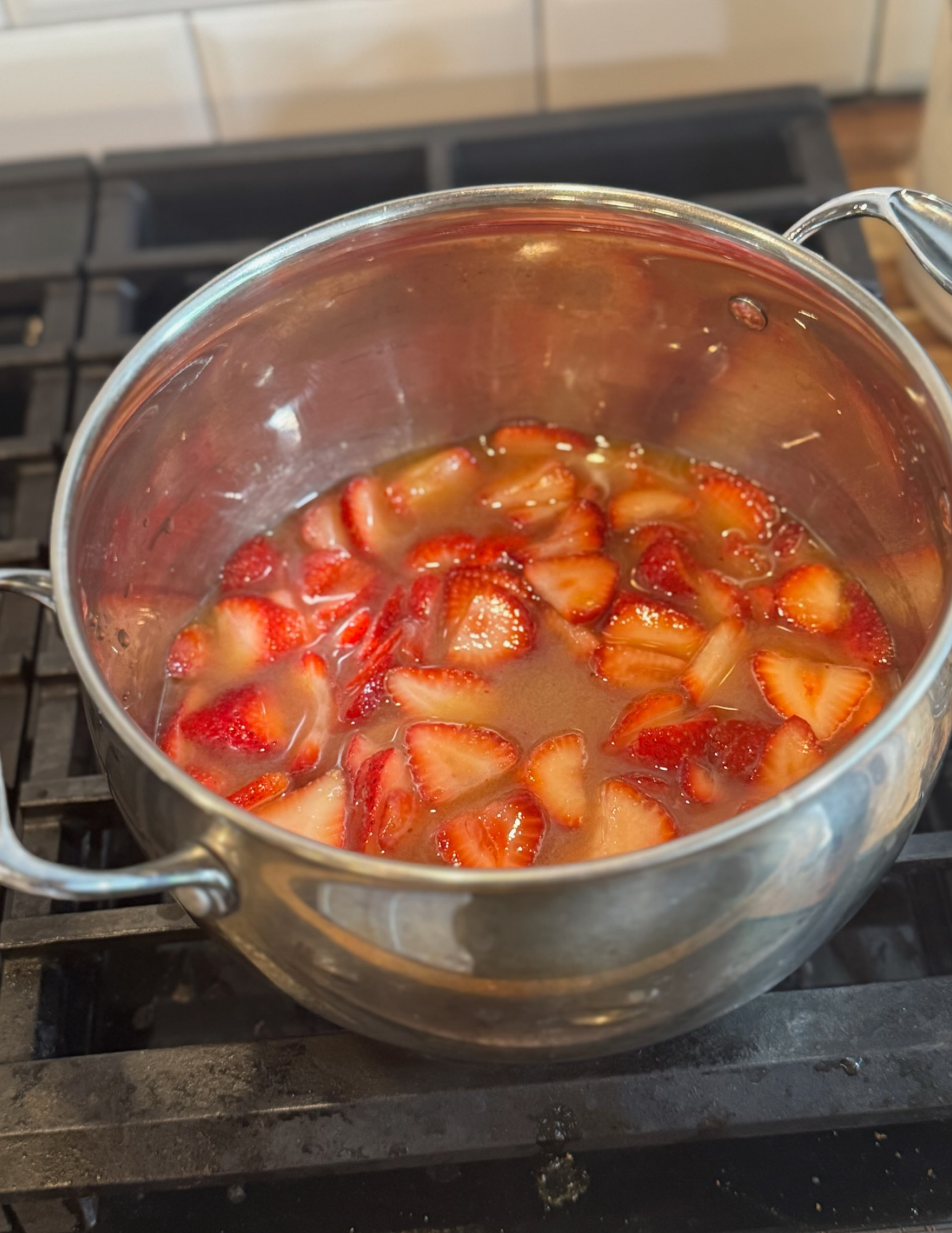 Fresh strawberries simmering in a pot for homemade jam.