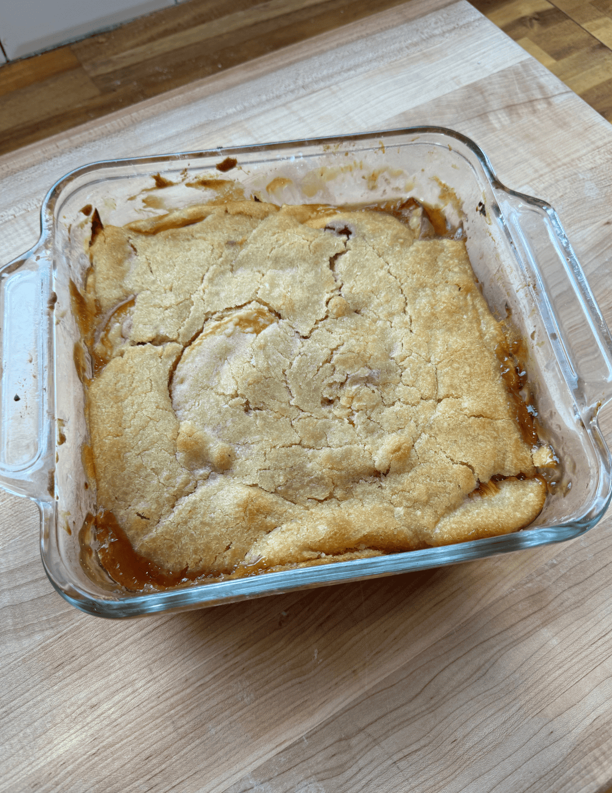 Freshly baked fruit cobbler in a glass baking dish, showcasing homemade dessert.
