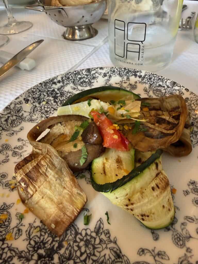 Grilled zucchini, eggplant, and peppers on a decorative plate at a restaurant in Paris.